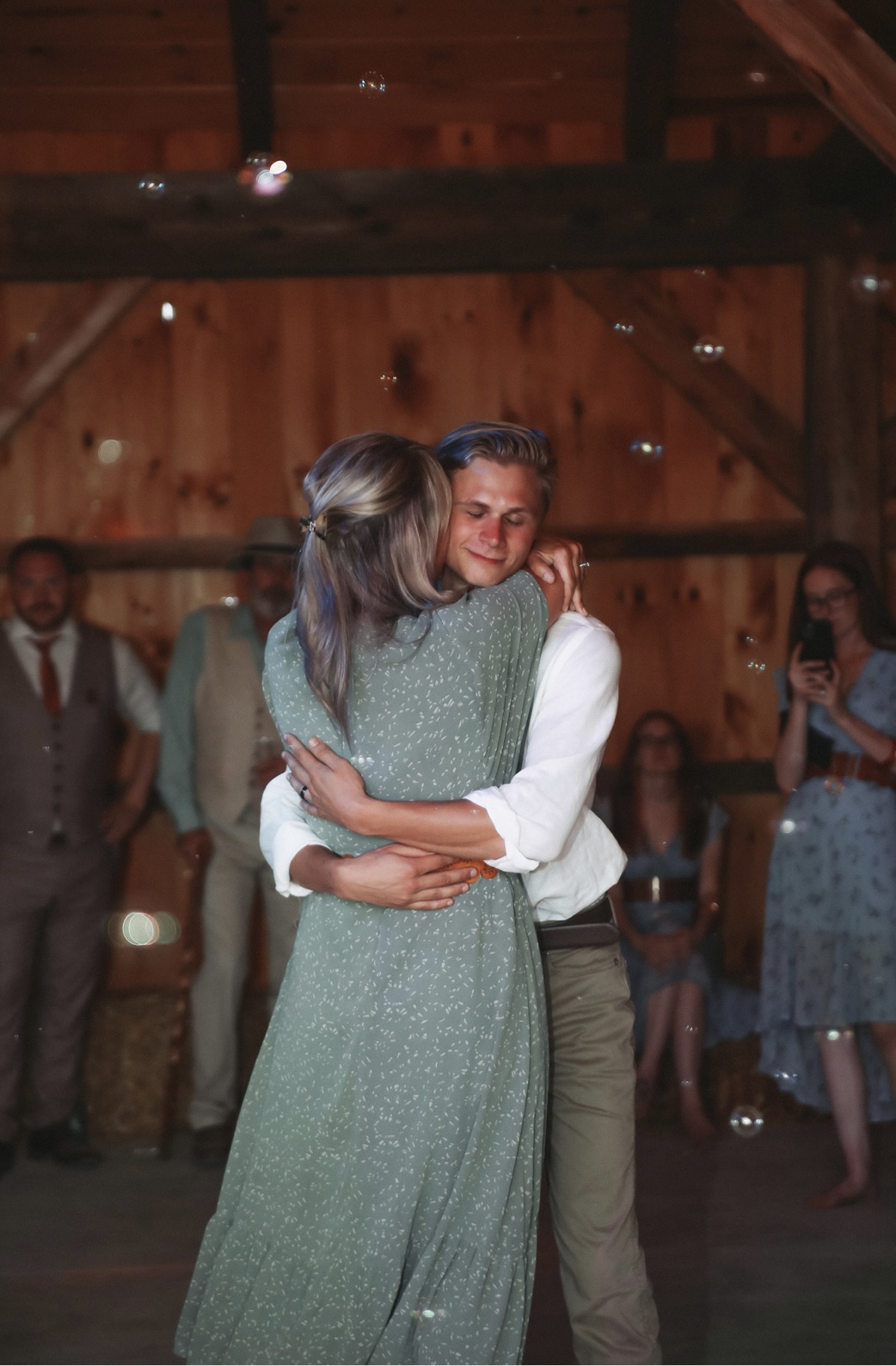 Man and Woman dancing in barn under twinkly lights.