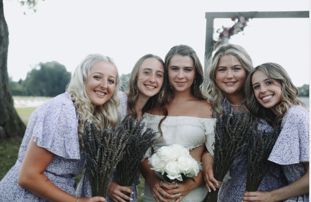 Bridal party posing for photo with bouquets of lavender.